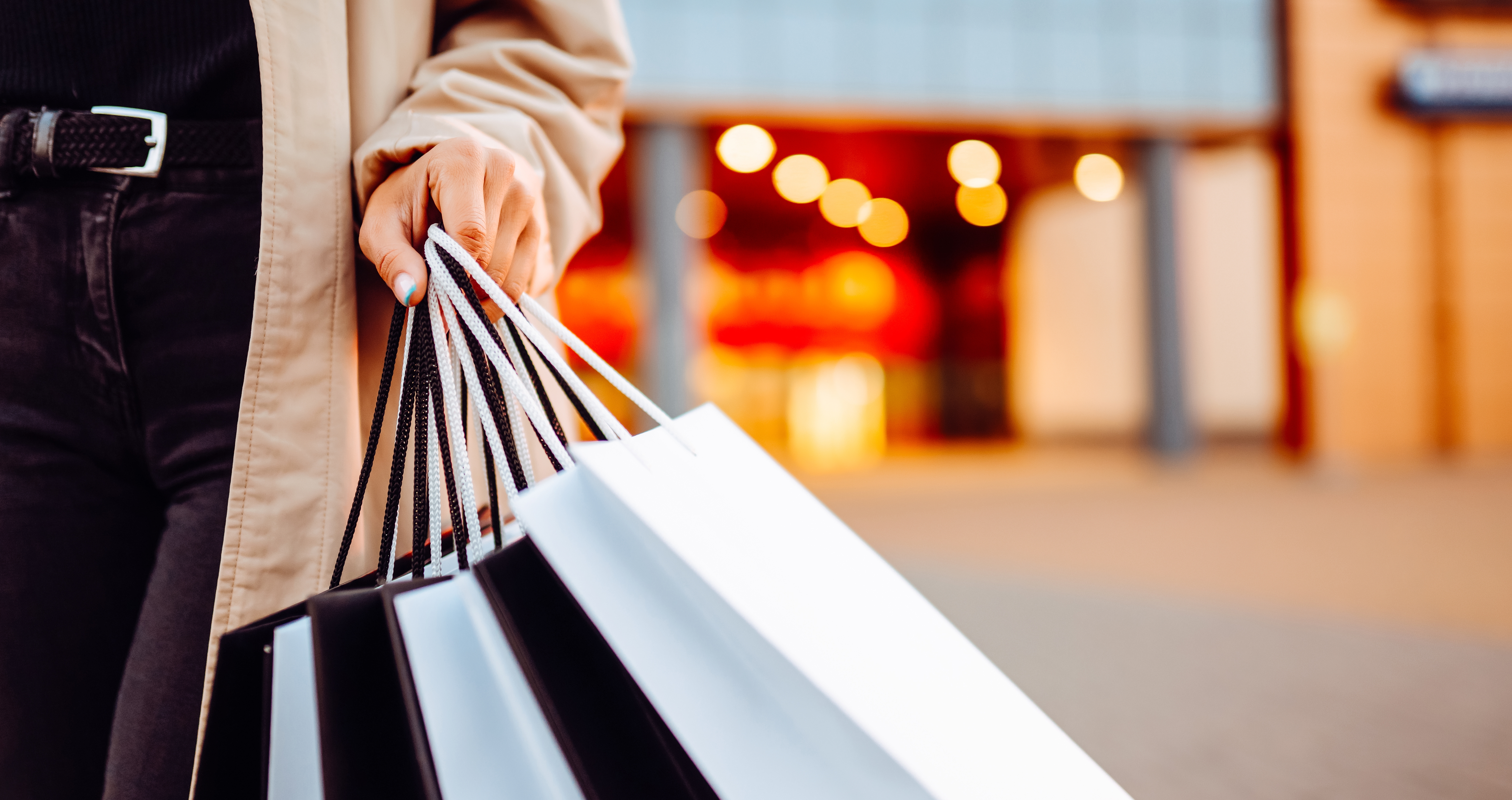 A close-up of a hand holding shopping bags